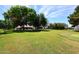 Expansive backyard featuring a lush green lawn, mature trees, and a putting green for recreational enjoyment at 17730 E Brooks Farm Rd, Gilbert, AZ 85298