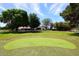 Expansive backyard featuring a lush lawn, mature trees, and a putting green for recreational enjoyment at 17730 E Brooks Farm Rd, Gilbert, AZ 85298