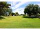 Expansive backyard features a well-maintained lawn, mature trees, and a putting green for recreational enjoyment at 17730 E Brooks Farm Rd, Gilbert, AZ 85298