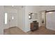 Bright entryway with neutral flooring, white trim, and decorative cabinet with mirror at 17730 E Brooks Farm Rd, Gilbert, AZ 85298