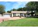 Inviting single-story home featuring charming curb appeal with a large lawn and mature trees at 17730 E Brooks Farm Rd, Gilbert, AZ 85298