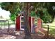 Charming red shed with white trim, surrounded by mature trees in a spacious yard at 17730 E Brooks Farm Rd, Gilbert, AZ 85298