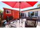 Backyard with red umbrella, red shed, table with chairs and desert landscaping and white house at 1982 E Oxford Dr, Tempe, AZ 85283