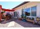 Cozy patio area featuring a red umbrella, a table with chairs, and a plant display bench at 1982 E Oxford Dr, Tempe, AZ 85283