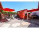 Backyard shed with double doors, red exterior, surrounded by gravel, patio furniture and shade umbrellas at 1982 E Oxford Dr, Tempe, AZ 85283