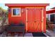 Rustic red backyard shed featuring double doors, small window, surrounded by decorative plants at 1982 E Oxford Dr, Tempe, AZ 85283