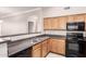 Modern kitchen with sleek black appliances, lighter wood cabinets, and durable countertops, blending style and functionality at 20100 N 78Th N Pl # 3212, Scottsdale, AZ 85255