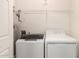 Bright laundry room features a modern washer, dryer, water heater, and a wire shelf for organized storage at 20100 N 78Th N Pl # 3212, Scottsdale, AZ 85255