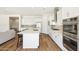 Open concept kitchen with a central island, modern appliances, white cabinets, and wood flooring throughout at 20606 E Avenida Del Valle Ct, Queen Creek, AZ 85142