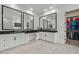 Bright bathroom featuring double vanity, granite counters, black framed mirrors, and a large walk-in closet at 22991 E Via De Olivos --, Queen Creek, AZ 85142