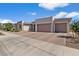 Beautiful new construction home featuring a three car garage and desert landscaping at 22991 E Via De Olivos --, Queen Creek, AZ 85142