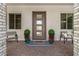 Charming front porch area with stylish seating and potted plants flanking the modern front door at 22991 E Via De Olivos --, Queen Creek, AZ 85142