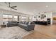 Open-concept living area flows into kitchen, featuring a large sectional sofa and bright, airy space at 22991 E Via De Olivos --, Queen Creek, AZ 85142
