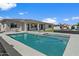 Backyard featuring a pool, outdoor seating, manicured lawn, and home's covered patio at 22991 E Via De Olivos --, Queen Creek, AZ 85142