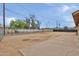 Spacious dirt backyard enclosed by a chain-link fence, and a concrete patio at 2617 N 40Th Ave, Phoenix, AZ 85009