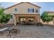 Backyard featuring a covered patio, gravel landscaping, mature trees, and the house's exterior at 26249 N 68Th Ln, Peoria, AZ 85383