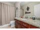 Bathroom with granite countertop, dark wood cabinets, and a shower-tub combination at 26249 N 68Th Ln, Peoria, AZ 85383