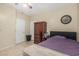 Bedroom features tile flooring, a ceiling fan, a mounted clock, and black-frame bed at 26249 N 68Th Ln, Peoria, AZ 85383