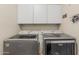 Laundry room with white cabinets and side-by-side gray Maytag washer and dryer at 26249 N 68Th Ln, Peoria, AZ 85383