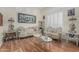 Elegant living room featuring hardwood floors, plantation shutters, and designer furnishings at 26249 N 68Th Ln, Peoria, AZ 85383