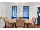 Bright dining room featuring wood table, upholstered chairs, and window with blue curtains at 2650 W Union Hills Dr # 100, Phoenix, AZ 85027