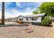 Charming single-story home with black and white trim with rock landscaping and flowering bushes at 2914 W Marlette Ave, Phoenix, AZ 85017