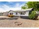 Charming single-story home with black and white trim with rock landscaping and flowering bushes at 2914 W Marlette Ave, Phoenix, AZ 85017