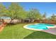 Lush backyard featuring a freeform pool, green grass, mature trees and comfortable lounge seating at 31227 N 45Th St, Cave Creek, AZ 85331