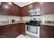 Modern kitchen with stainless steel appliances, sleek countertops, and dark wood cabinets at 31227 N 45Th St, Cave Creek, AZ 85331