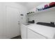 Bright laundry room featuring modern washing machines and a sturdy shelving unit at 31227 N 45Th St, Cave Creek, AZ 85331