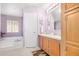 Bathroom featuring double sinks, wooden cabinets, a tub, and natural lighting at 33852 N 52Nd St, Cave Creek, AZ 85331