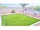 Backyard featuring string lights, artificial grass, and desert landscaping at 3402 N 300Th Dr, Buckeye, AZ 85396