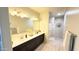 Bright and airy bathroom with double sinks, a large mirror, and plank flooring at 3402 N 300Th Dr, Buckeye, AZ 85396