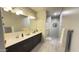 Bright and airy bathroom with double sinks, a large mirror, and plank flooring at 3402 N 300Th Dr, Buckeye, AZ 85396
