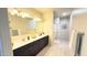 Bright and airy bathroom with double sinks, a large mirror, and plank flooring at 3402 N 300Th Dr, Buckeye, AZ 85396