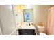 Modern bathroom with dark vanity, a mirror, neutral walls, toilet, sink and white door at 3402 N 300Th Dr, Buckeye, AZ 85396