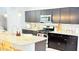 Close up of kitchen with dark cabinets, granite countertops, and stainless steel appliances at 3402 N 300Th Dr, Buckeye, AZ 85396