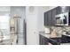 Stylish kitchen with stainless steel appliances, dark cabinetry, and granite countertops at 3402 N 300Th Dr, Buckeye, AZ 85396