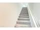 Carpeted staircase with white walls and handrail provides access to the upper level of the home at 3402 N 300Th Dr, Buckeye, AZ 85396