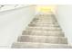 Carpeted stairway leading to a brightly lit area with wood floors and a yellow rug at 3402 N 300Th Dr, Buckeye, AZ 85396