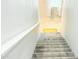 Carpeted stairway leading to a brightly lit area with wood floors and a yellow rug at 3402 N 300Th Dr, Buckeye, AZ 85396