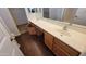 Bathroom featuring double sinks, wood-look flooring, and vanity storage with warm cabinetry at 3405 W La Salle St, Phoenix, AZ 85041