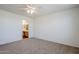Bright carpeted bedroom featuring ceiling fan and a connected bathroom with vanity at 3405 W La Salle St, Phoenix, AZ 85041