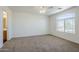 Comfortable bedroom featuring plush carpet, a ceiling fan and a large window at 3405 W La Salle St, Phoenix, AZ 85041