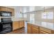 Modern kitchen with stainless steel appliances and black oven range open to living and dining space at 3405 W La Salle St, Phoenix, AZ 85041