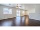 Open-concept living room with sliding glass doors to backyard, ceiling fan, and hardwood floors at 3405 W La Salle St, Phoenix, AZ 85041