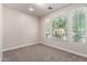 Bright bedroom featuring carpet flooring, white walls, and two windows with privacy blinds at 3477 E Sheffield Rd, Gilbert, AZ 85296