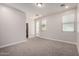 This bedroom is a blank canvas with neutral carpet, white walls, and natural light from the doorway and window at 3477 E Sheffield Rd, Gilbert, AZ 85296