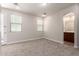 Bright bedroom featuring carpet flooring, white walls, and an entrance to the ensuite bathroom at 3477 E Sheffield Rd, Gilbert, AZ 85296