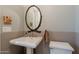 Elegant powder room featuring a pedestal sink and a unique branch-like framed oval mirror at 36298 N Crucillo Dr, Queen Creek, AZ 85140